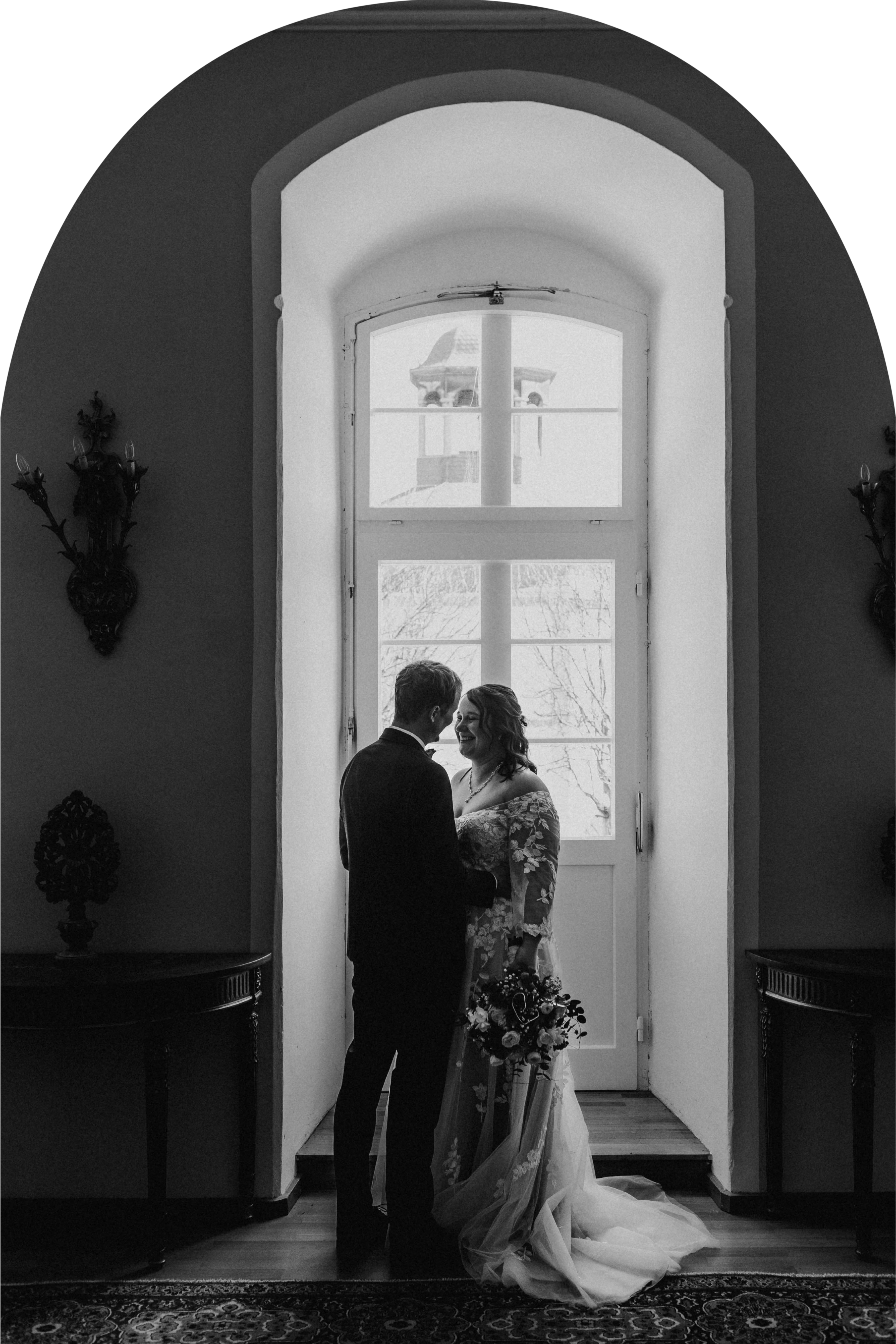 Romantische heiraten: Hochzeitspaar vor großem Fenster im Schloss Jägersburg